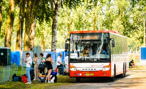 Bezoekers stappen uit pendelbus Bezoekers stappen uit pendelbus