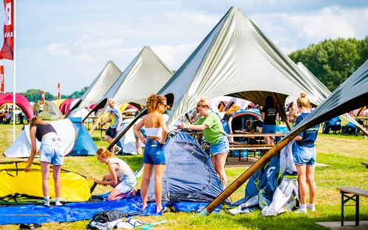 Bezoekers bouwen hun tentje op op de Groepscamping