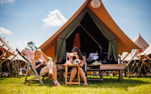 2 vrouwelijke Lowlanders zitten voor hun Gllamcamp tent